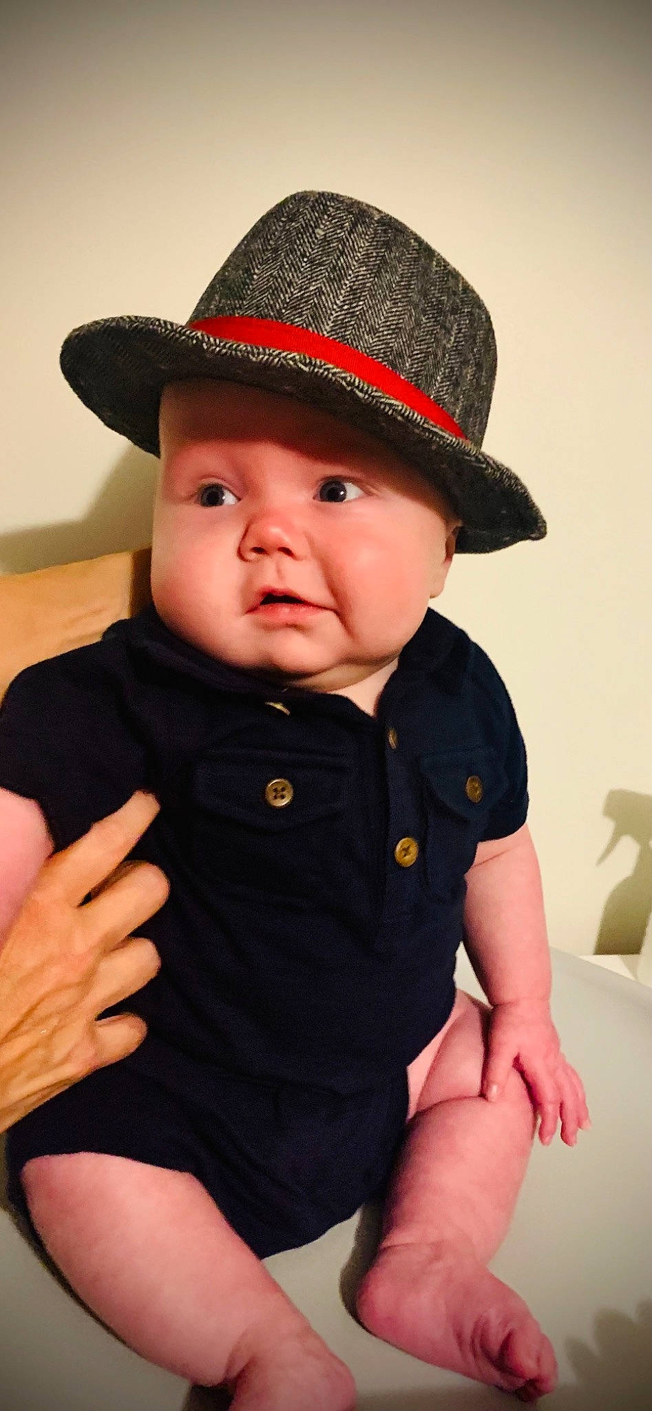 Benjamin is registered to the contest to win money with this photo: arm, baby, baby_toddler_clothing, cap, cheek, chin, fedora, finger, gesture, hat, headgear, headwear, human, iris, lip, neck, person, skin, sleeve, sun_hat