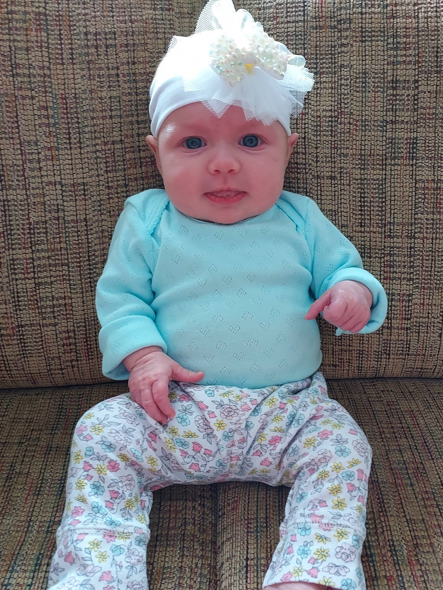 Leia is registered to the contest to win money with this photo: baby, baby_toddler_clothing, cap, cheek, chin, costume_hat, dress, eye, face, head, headwear, human_body, leg, lip, pattern, person, pink, skin, sleeve, textile