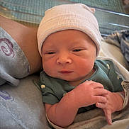 Reed joined the competition — help win amazing prizes! baby, newborn, infant, hat, wristband, blanket, swaddle, hospital_bed, adult_arm, crib, close_up, portrait, tiny_hands, sleepy, cozy, green_clothing, striped_hat, skin, facial_expression, hospital_gown