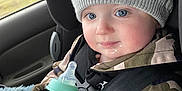 Tobias joined the competition — help win amazing prizes! baby, beverage, bodypart, bonnet, bottle, cap, car, clothing, coat, face, finger, hand, hat, head, milk, person, photography, portrait, transportation, vehicle