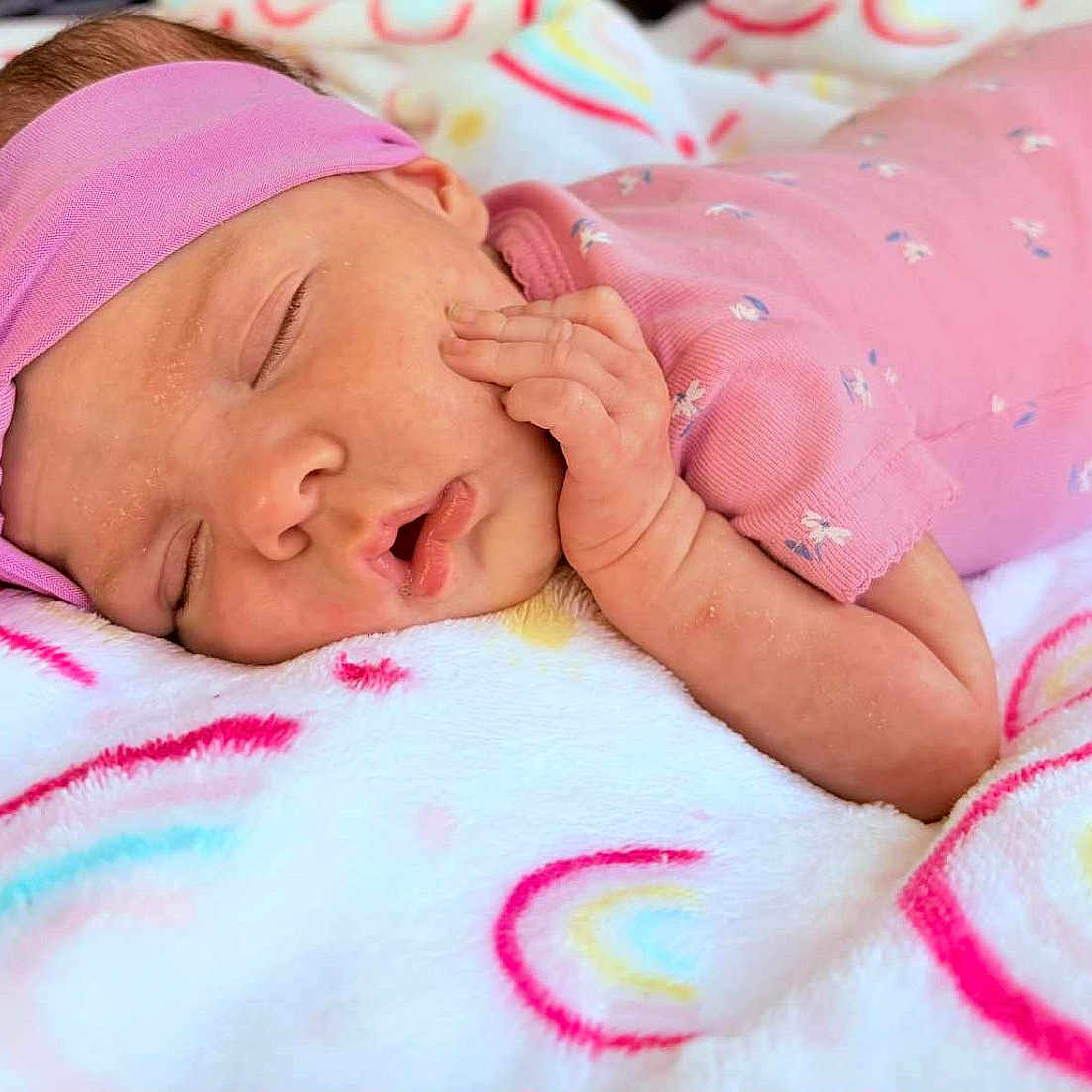 Rylee is registered to the contest to win money with this photo: baby, blanket, child, closeup, comfort, cozy, cute, face, hand, headband, indoors, infant, newborn, peaceful, pink_clothing, portrait, rainbow_pattern, resting, sleeping, soft_texture