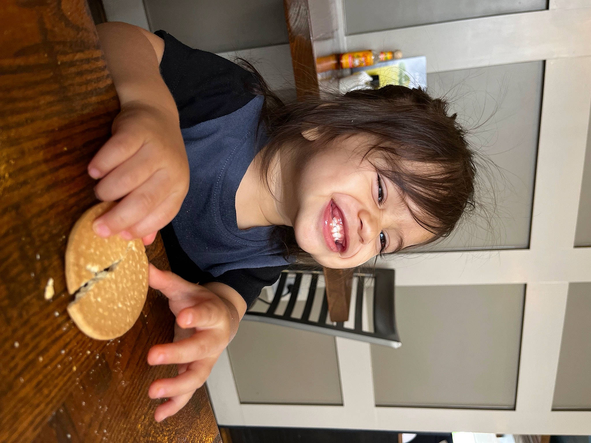 King is registered to the contest to win money with this photo: child, circle, cooking, finger_food, food, fun, hand, happy, joy, person, plate, room, smile, sunglasses, t_shirt, table, tableware, thumb, toddler, wood