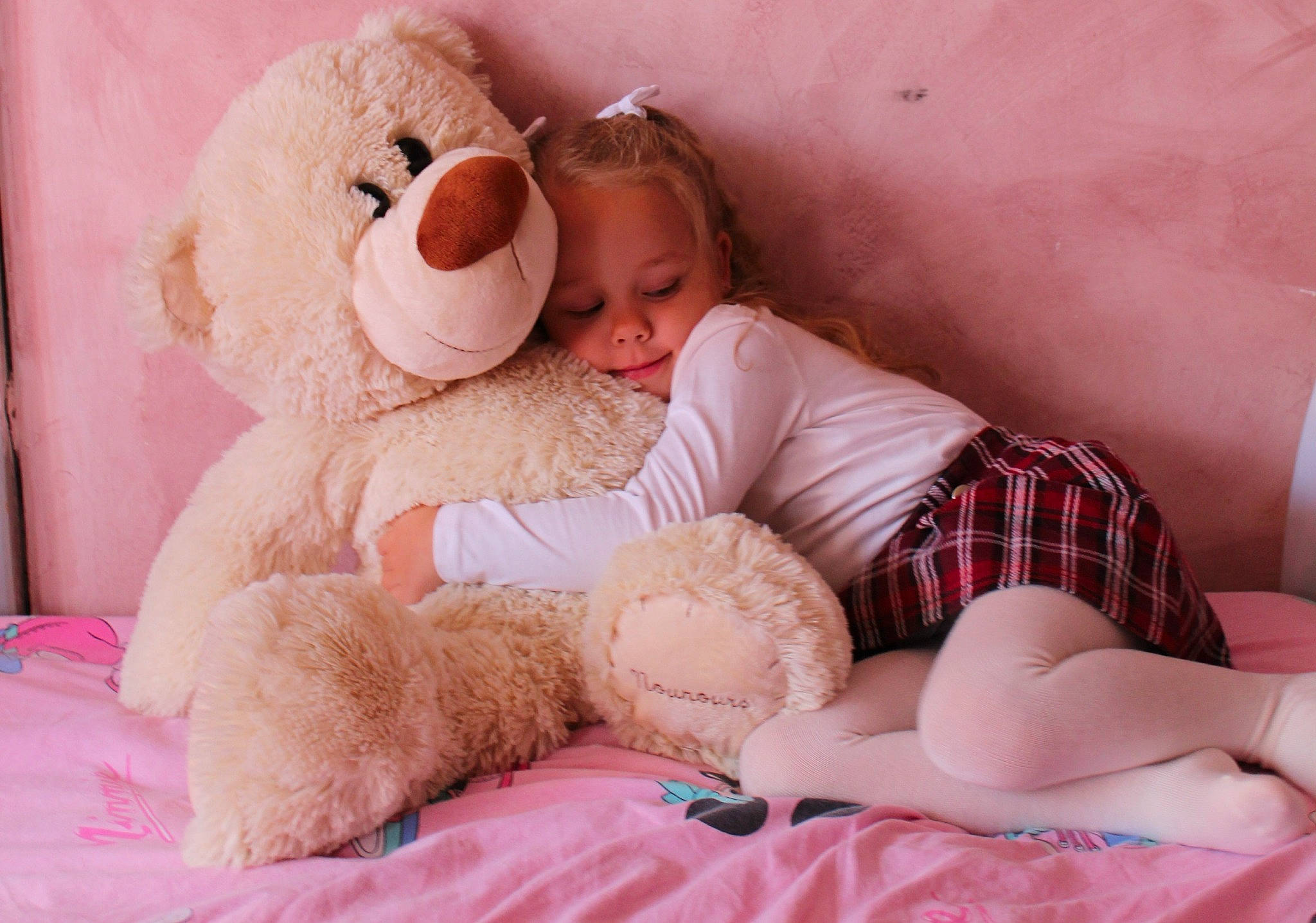 Edene a rejoint le concours — aidez-le/la à gagner de superbes lots ! abdomen, baby_sleeping, bed, child, comfort, couch, facial_expression, happy, human_leg, interaction, knee, linens, mammal, person, pink, skin, stuffed_toy, teddy_bear, textile, thigh