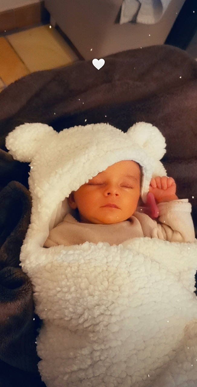 Marie-lou a rejoint le concours — aidez-le/la à gagner de superbes lots ! baby, baby_sleeping, baby_toddler_clothing, beanie, bonnet, cap, cheek, child, comfort, fur, happy, headwear, knit_cap, linens, person, portrait_photography, room, sitting, sleeve, toddler