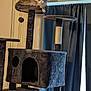 cat, cat_tree, indoor, pet, feline, relaxed, plush, furniture, curtain, window, animal, resting, home, gray_cat, vertical, multi_level, soft_texture, domestic, cozy, lounging