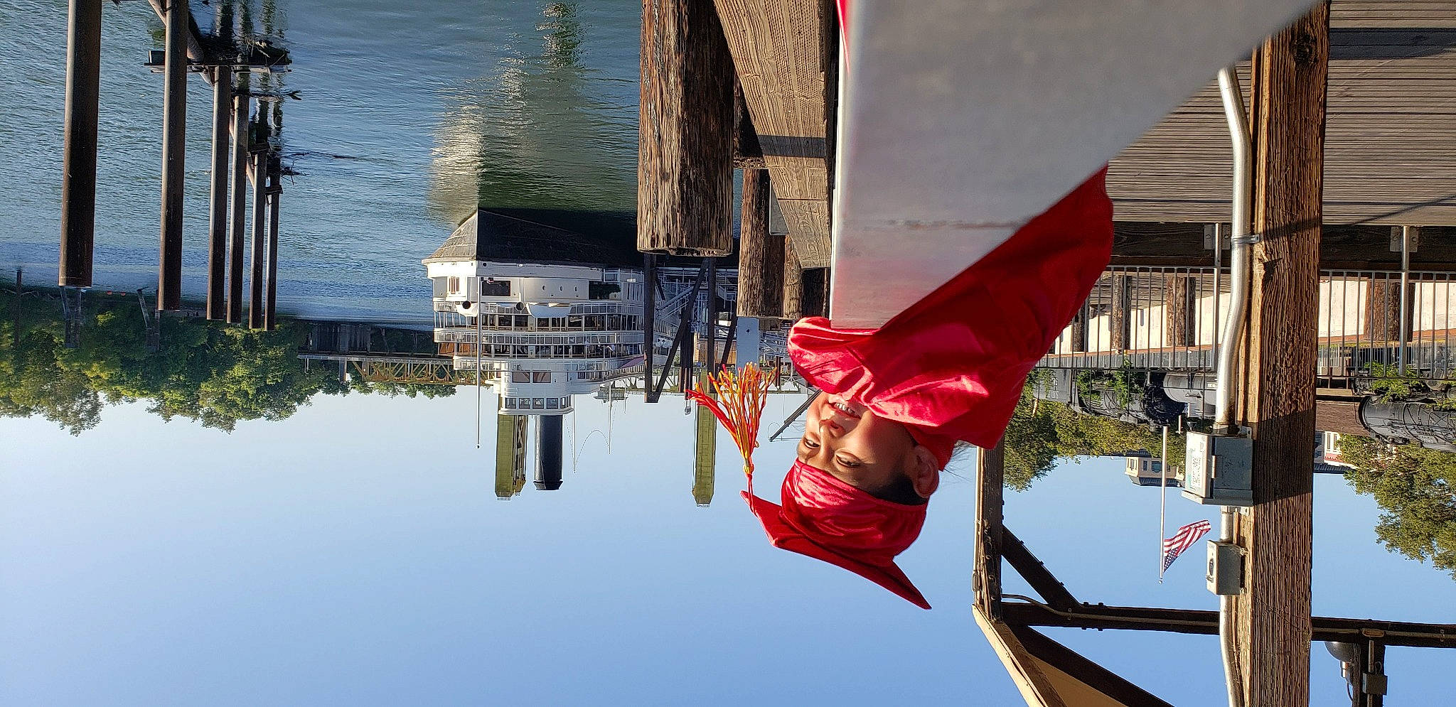 Adrian is registered to the contest to win money with this photo: flag, flower, headwear, person, plant, red, reflection, vacation, water