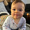 Aiden is registered to the contest to win money with this photo: baby, child, face, eyes, smile, onesie, high_chair, indoor, cute, portrait, curious, hands, patterned_clothing, polka_dots, cushion, soft_lighting, cozy, infant, person, young