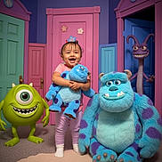Cataleya joined the competition — help win amazing prizes! toddler, child, plush_toy, sulley, mike_wazowski, randall_boggs, monsters_inc, colorful_doors, pink_door, blue_door, green_door, purple_door, carpet, smiling, indoor, playing, happy, person, toy, fantasy
