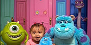 Cataleya joined the competition — help win amazing prizes! toddler, child, plush_toy, monster, cartoon_character, colorful_doors, pink_door, green_door, blue_door, carpet, smile, indoor, happy, fantasy, playful, cute, purple_spots, toy, room, imaginative