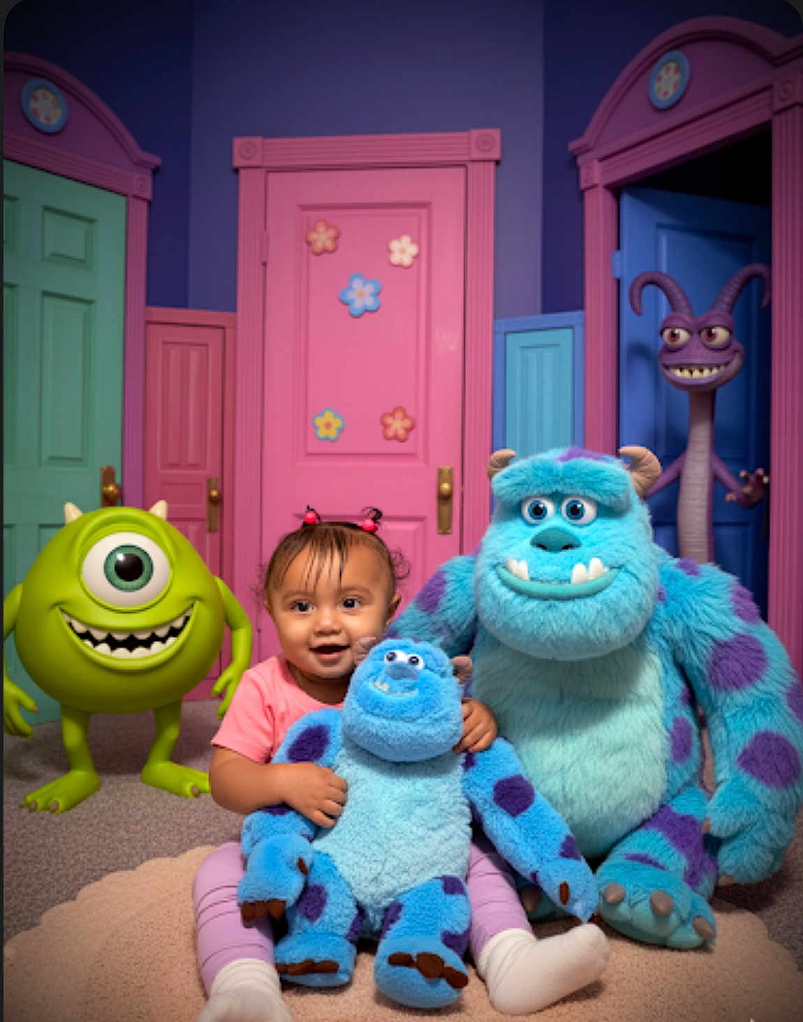 Cataleya joined the competition — help win amazing prizes! toddler, child, plush_toy, monster, cartoon_character, colorful_doors, pink_door, green_door, blue_door, carpet, smile, indoor, happy, fantasy, playful, cute, purple_spots, toy, room, imaginative