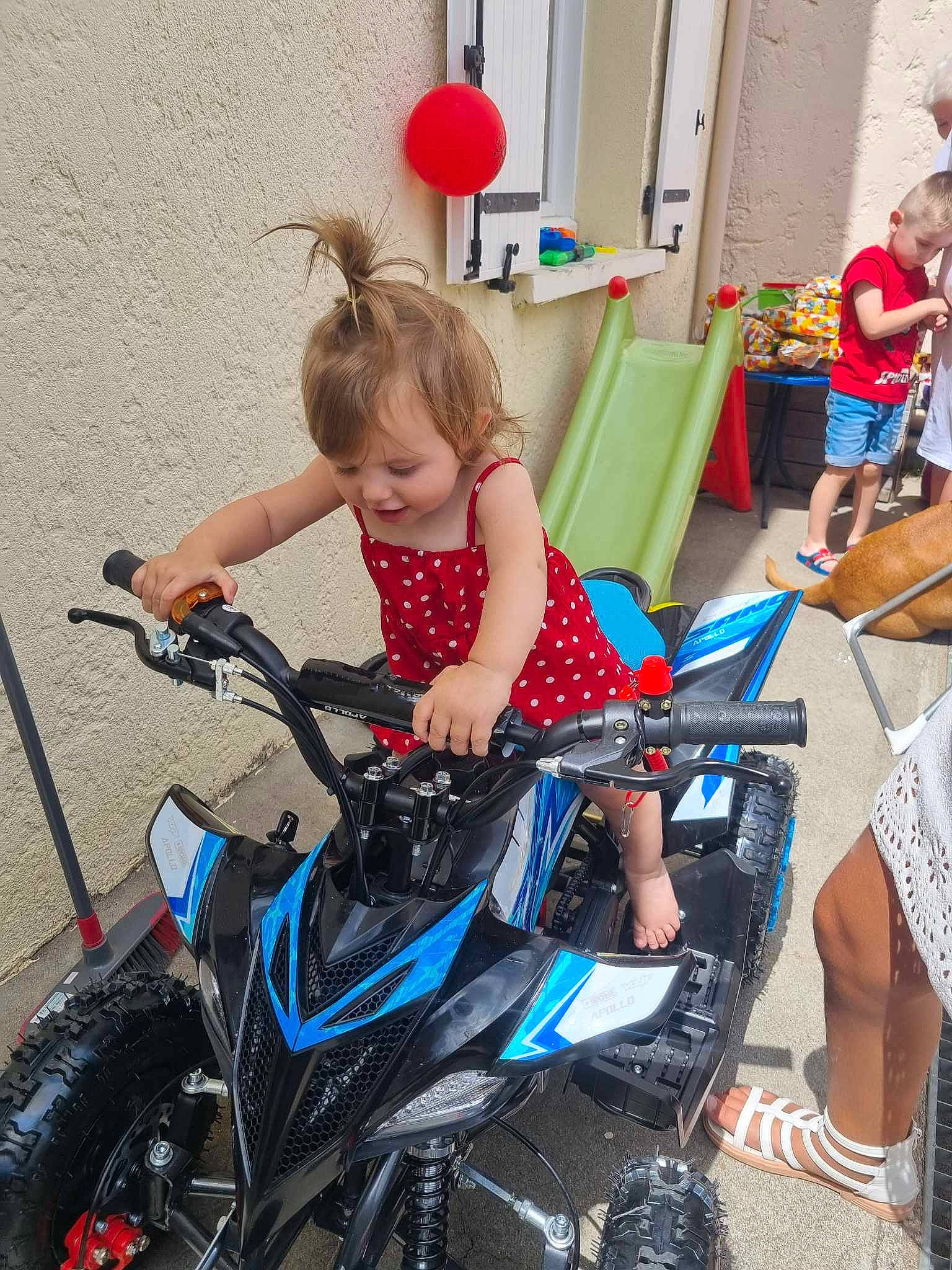 Louna participe au concours pour gagner de l'argent avec cette photo : auto_part, automotive_design, automotive_exterior, automotive_lighting, automotive_tire, automotive_wheel_system, electric_blue, event, motor_vehicle, motorcycle, person, recreation, rim, shoe, shorts, smile, spoke, tire, toddler, vehicle
