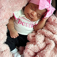 Blessing is registered to the contest to win money with this photo: baby, sleeping, pink_headband, blanket, infant, cozy, cute, newborn, soft_texture, child, clothing, pink, white_shirt, black_pants, socks, portrait, resting, toddler, peaceful, indoor
