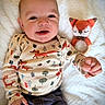 Jasper is registered to the contest to win money with this photo: baby, child, smiling, cute, fox, knitted_toy, toy, blanket, white, clothing, pattern, infant, lying_down, happy, portrait, face, hand, cozy, indoor, soft
