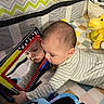 baby, reflection, mirror, pajamas, toy, plush_toy, nursery, blanket, child, infant, striped_clothing, playtime, soft_toy, colorful, face, curious, indoor, crawling, smiling, closeup