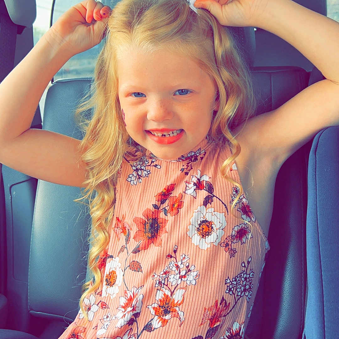 Harlynn is registered to the contest to win money with this photo: accessories, belt, blonde, child, clothing, cushion, dress, face, female, formalwear, girl, hair, happy, head, homedecor, person, photography, portrait, sitting, smile