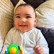 Keïssy a rejoint le concours — aidez-le/la à gagner de superbes lots ! baby, child, smiling, toy, colorful, cushion, blanket, indoor, closeup, happy, infant, face, hand, clothing, cute, young, portrait, playful, warm, comfort