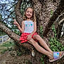 child, girl, tree, nature, outdoor, smile, peace_sign, tank_top, skirt, ivy, branch, footwear, sandals, greenery, forest, happy, posing, casual_clothing, daylight, relaxation