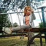 bench, casual_clothing, child, curious, daytime, fence, grass, metal_chains, outdoor, pacifier, park, person, playground, red_hair, sky, sneakers, swing, tree, wooden_swing, young