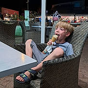 Tomy participe au concours pour gagner de l'argent avec cette photo : boy, chair, child, cone, happy, ice_cream, market, night, outdoor, pavement, people, relaxed, sandals, shop, shorts, smiling, streetlight, table, tshirt, wicker