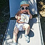 Manoé participe au concours pour gagner de l'argent avec cette photo : baby, child, sunglasses, cap, outdoor, sunlight, shadow, chair, clothing, card, fairy, relaxing, playful, sock, summer, cute, portrait, person, nature, daylight