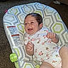 baby, infant, smiling, onesie, baby_bouncer, patterned_fabric, carpet, indoors, child, person, happy, cute, small_hands, floral_print, furniture, seat, resting, skin, head, hair