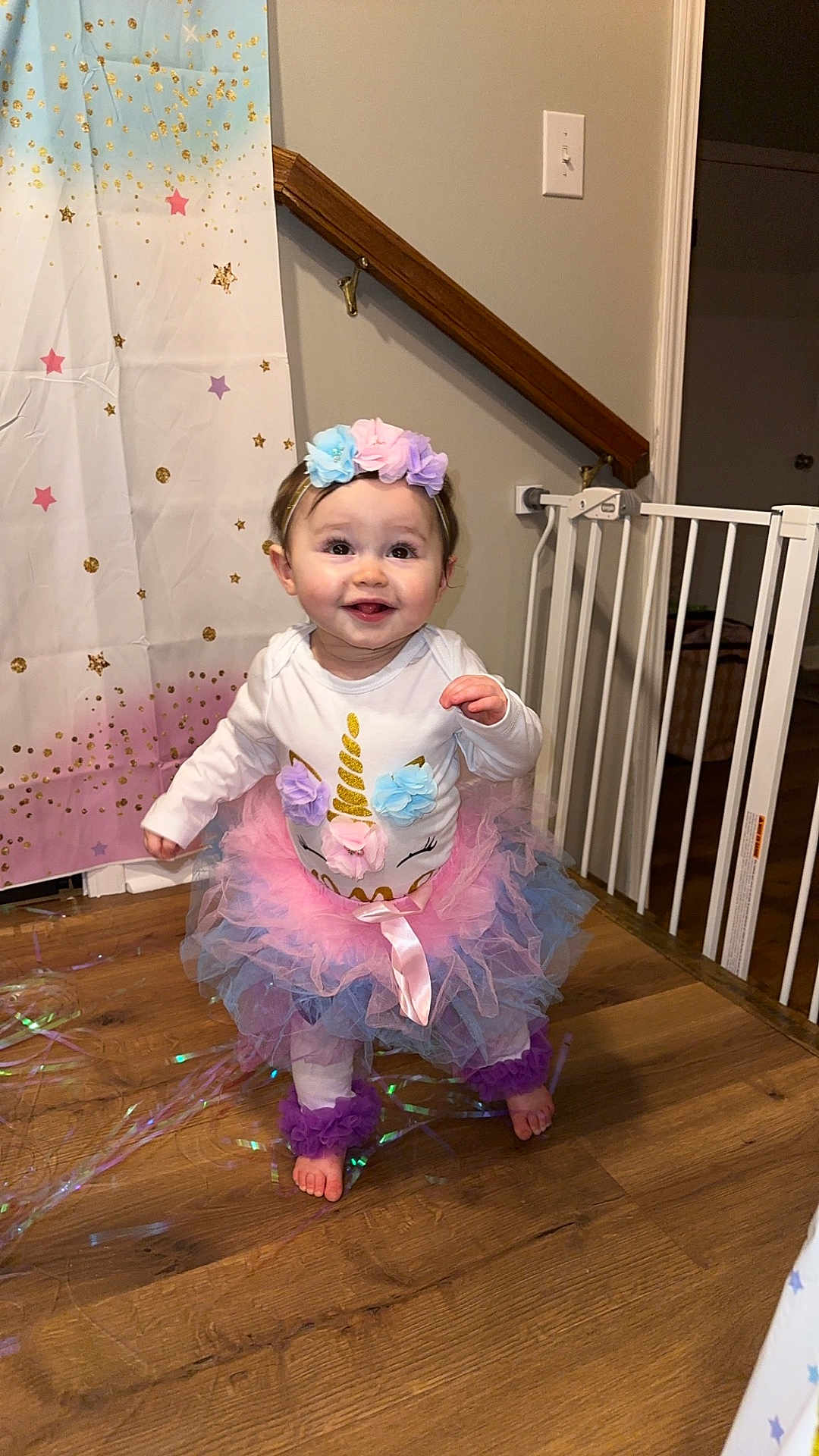 Karlee joined the competition — help win amazing prizes! baby, child, unicorn, tutu, headband, flower, smile, indoor, wooden_floor, curtain, star_pattern, baby_gate, purple, pink, blue, white_clothing, cute, happy, toddler, decor