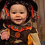 Karlee joined the competition — help win amazing prizes! baby, child, costume, scarecrow, smile, face, hat, yarn, orange_ribbon, button, patchwork, sleeve, hand, wooden_wall, indoor, portrait, cute, happy, person, holiday