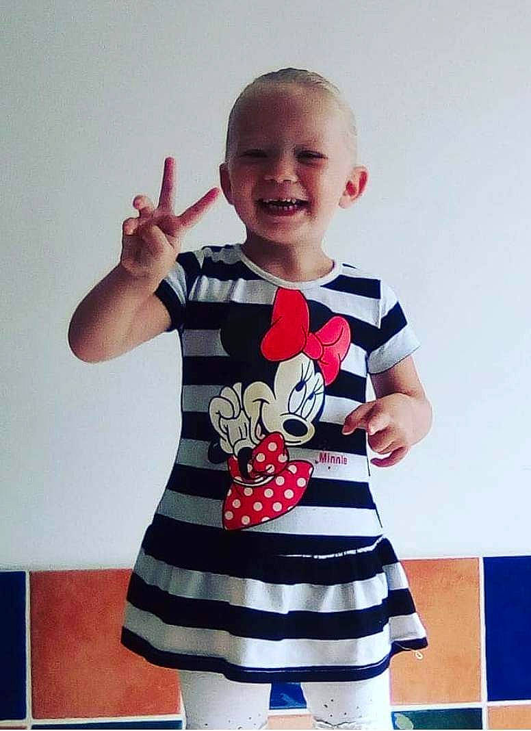 Maelya a rejoint le concours — aidez-le/la à gagner de superbes lots ! arm, baby_toddler_clothing, child, collar, electric_blue, event, fashion, finger, gesture, happy, human_body, joy, magenta, neck, pattern, person, sleeve, smile, t_shirt, thumb