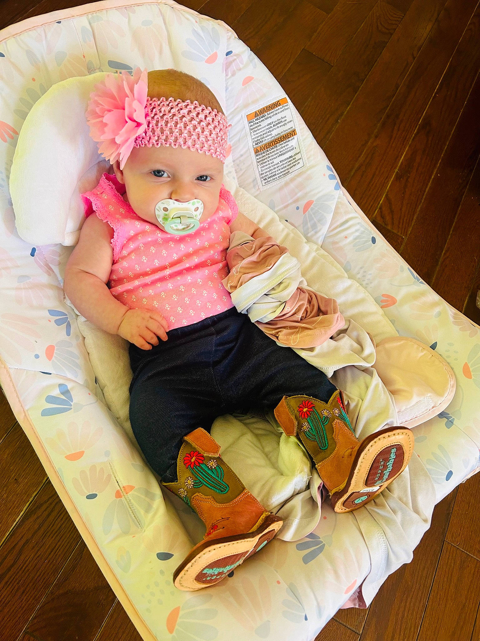 Harper is registered to the contest to win money with this photo: baby, baby_products, baby_safety, baby_sleeping, baby_toddler_clothing, child, comfort, foot, headwear, human_leg, knee, lap, linens, pattern, person, room, sitting, sleeve, sock, thigh