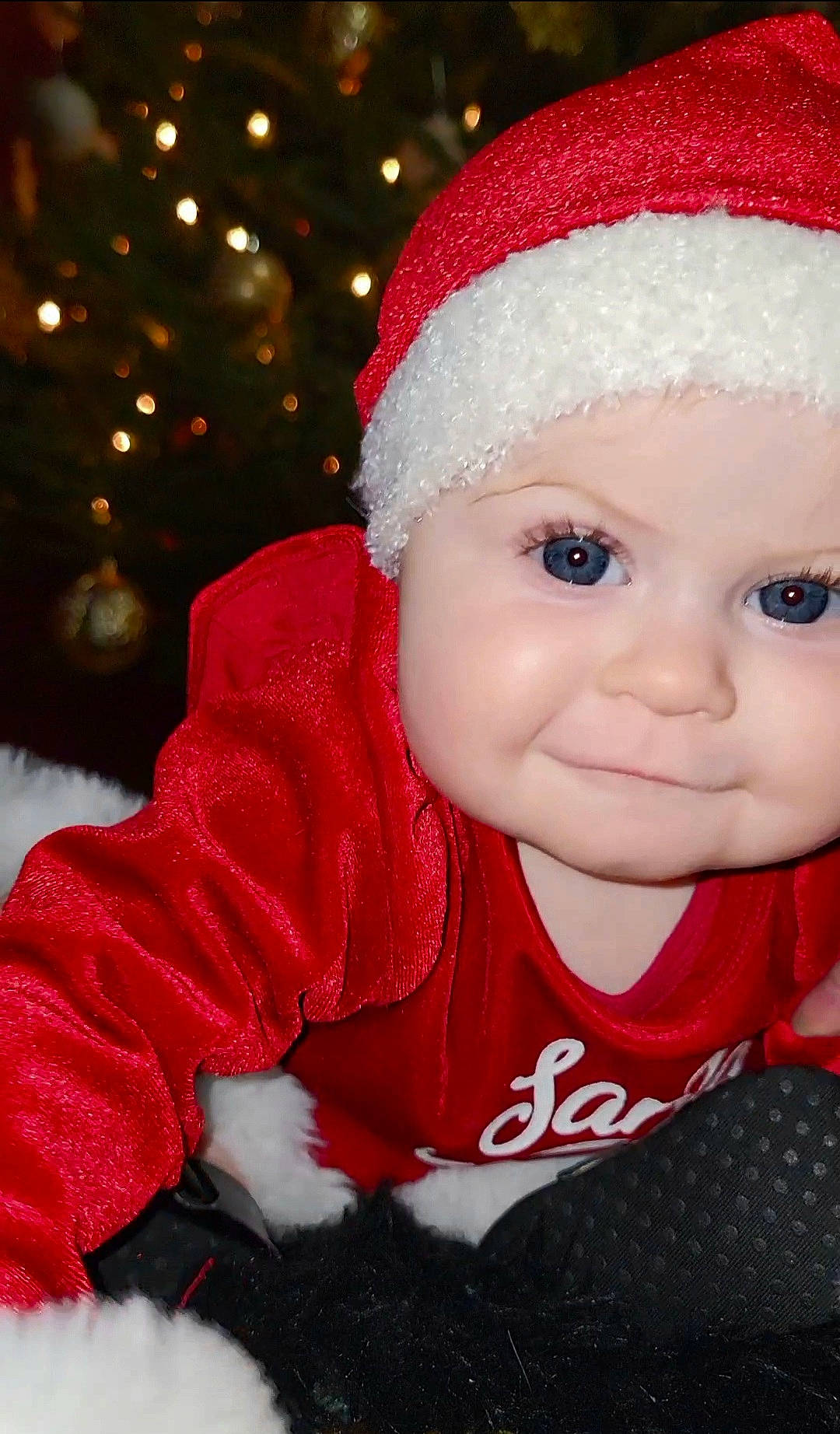Rylee joined the competition — help win amazing prizes! baby, baby_toddler_clothing, cap, cheek, christmas, christmas_decoration, christmas_eve, christmas_ornament, christmas_tree, event, eye, facial_expression, happy, hat, head, headwear, holiday, human_body, person, santa_claus
