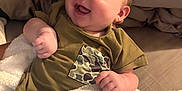 Easton joined the competition — help win amazing prizes! baby, infant, smiling, blanket, shirt, camo_pocket, happy, face, skin, hand, bed, bedding, cozy, chubby_cheeks, young_child, cute, indoors, soft_texture, lying_down, comfort