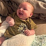 Easton joined the competition — help win amazing prizes! baby, infant, smiling, blanket, shirt, camo_pocket, happy, face, skin, hand, bed, bedding, cozy, chubby_cheeks, young_child, cute, indoors, soft_texture, lying_down, comfort