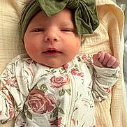 Presley is registered to the contest to win money with this photo: baby, infant, headband, bow, floral, onesie, blanket, sleepwear, cute, face, hand, skin, newborn, child, portrait, lying_down, soft, cozy, indoors, resting
