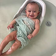 Joshua is registered to the contest to win money with this photo: baby, bath, water, smile, happy, infant, towel, bathtub, skin, child, person, seat, relaxing, cute, young, sitting, wet, playful, indoors, clean