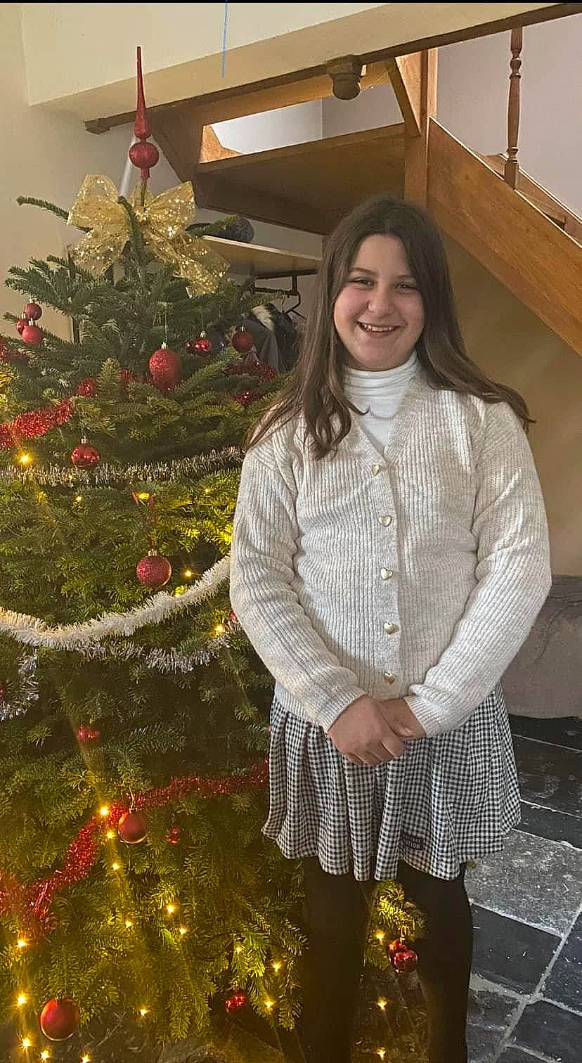 Olivia a rejoint le concours — aidez-le/la à gagner de superbes lots ! beauty, christmas_decoration, christmas_ornament, christmas_tree, conifer, event, evergreen, facial_expression, fashion_design, hairstyle, happy, holiday, holiday_ornament, joy, ornament, pattern, person, sleeve, smile, standing