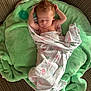 Riott is registered to the contest to win money with this photo: baby, newborn, sleeping, blanket, green_blanket, pacifier, couch, striped_couch, infant, wrapped, peaceful, soft_texture, indoors, natural_light, child, person, cute, relaxing, home, portrait