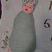 Elizabeth is registered to the contest to win money with this photo: baby, infant, swaddle, headband, leopard_print, blanket, floral_pattern, numbers, lying_down, cute, adorable, child, newborn, face, portrait, soft_texture, pink, green, sleepwear, resting