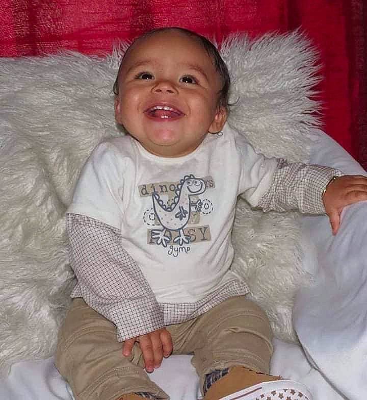 Kayden is registered to the contest to win money with this photo: baby, baby_toddler_clothing, cheek, child, comfort, eye, happy, iris, joy, khaki_pants, linens, mammal, organ, pattern, people, person, sitting, skin, sleeve, smile