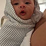 Louis participe au concours pour gagner de l'argent avec cette photo : baby, blanket, child, closeup, cuddle, curious, expression, face, head, indoor, infant, newborn, person, portrait, skin, soft, striped, towel, wrapped, young