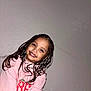 child, smiling, braided_hair, pink_sweatshirt, strawberry_design, portrait, indoor, wall, happy, cute, young, person, face, long_hair, casual_clothing, fashion, childhood, joyful, skin, human