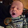 Keagan is registered to the contest to win money with this photo: baby, infant, yawn, onesie, striped_clothing, pacifier, face, mouth_open, person, hand, indoor, wooden_table, clothing, newborn, candid, baby_brother, portrait, child, human, cute