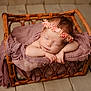 Marnie joined the competition — help win amazing prizes! baby, newborn, sleeping, basket, flower_crown, pink, soft_cloth, wooden_floor, peaceful, infant, portrait, cute, resting, headband, wrapped, skin, hands, closeup, indoors, cozy