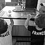 Eden Et Nolan a rejoint le concours — aidez-le/la à gagner de superbes lots ! back_view, ball, black_and_white, candid, carpet, child, cute, furniture, glass_table, hair, home, indoor, living_room, person, play, reaching, sitting, toddler, tshirt, two_children