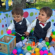 Eden Et Nolan participe au concours pour gagner de l'argent avec cette photo : ball_pit, bow_tie, child, colorful_balls, cute, daytime, feet, fun, grass, happy, outdoor, person, playing, sitting, sock, summer, toddler, toy, tree, vest