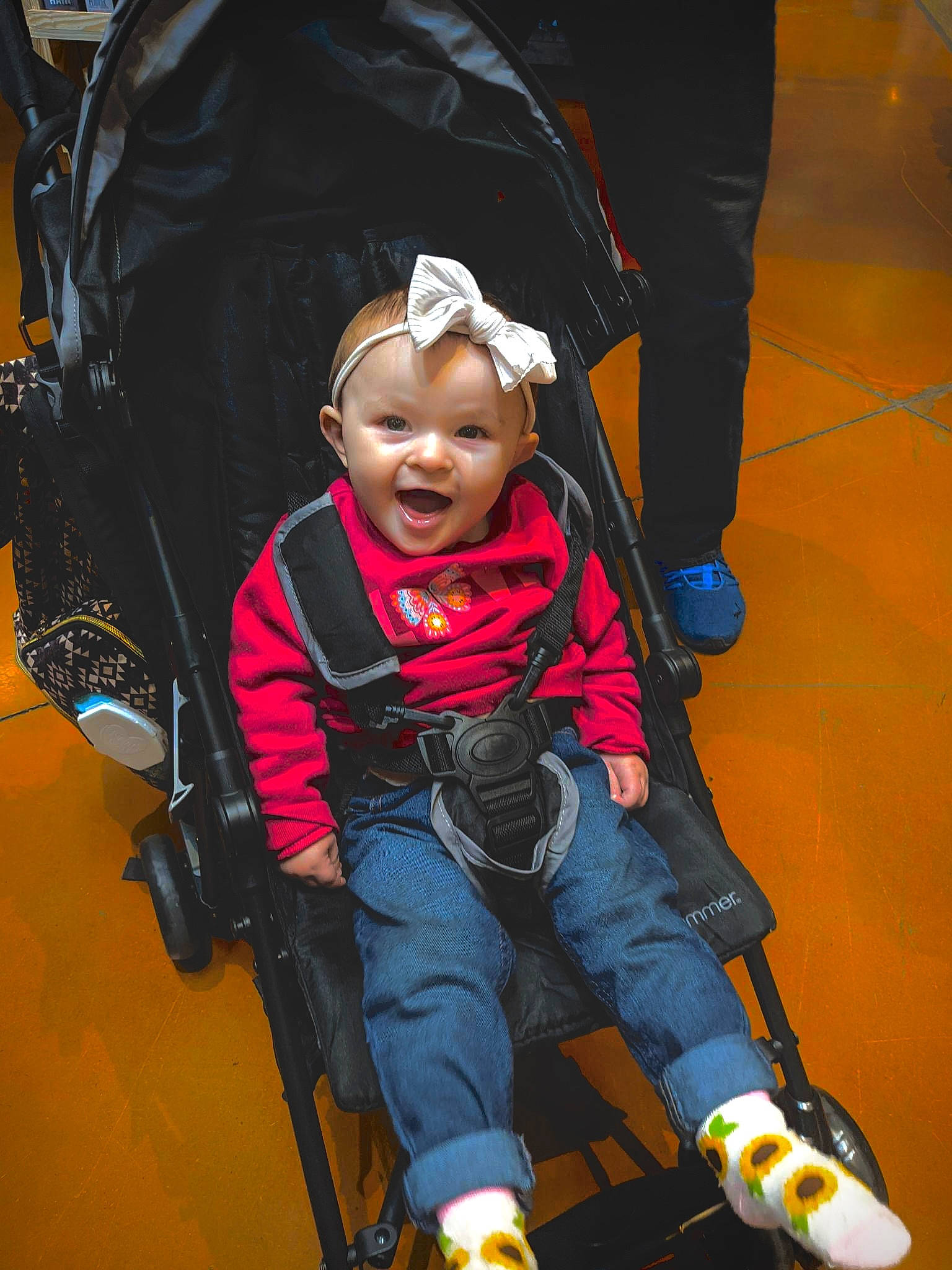 Desiree is registered to the contest to win money with this photo: auto_part, automotive_design, baby, baby_carriage, baby_products, baby_safety, bag, chair, child, comfort, electric_blue, flooring, fun, lap, leisure, motor_vehicle, person, sitting, smile, sneakers