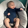 Alexander is registered to the contest to win money with this photo: baby, infant, child, onesie, blue_clothing, baby_seat, cushion, indoor, floor, skin, bare_feet, legs, arms, face, head, expression, curious, seated, young, person