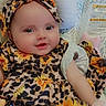 baby, child, smiling, face, headband, flower_pattern, leopard_print, clothing, seat, cushion, indoors, portrait, cute, happy, infant, colorful, soft_toys, baby_girl, fabric, closeup