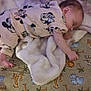 baby, sleeping, blanket, pacifier, playmat, cartoon_animals, giraffe, lion, hippo, infant_clothing, minnie_mouse, soft_texture, cute, child, lying_down, indoors, peaceful, toes, fluffy, cozy