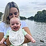 Noah is registered to the contest to win money with this photo: affection, baby, bib, blonde_hair, child, clothing, duck, family, happy, holding, lake, love, nature, outdoor, person, sky, smiling, trees, water, woman