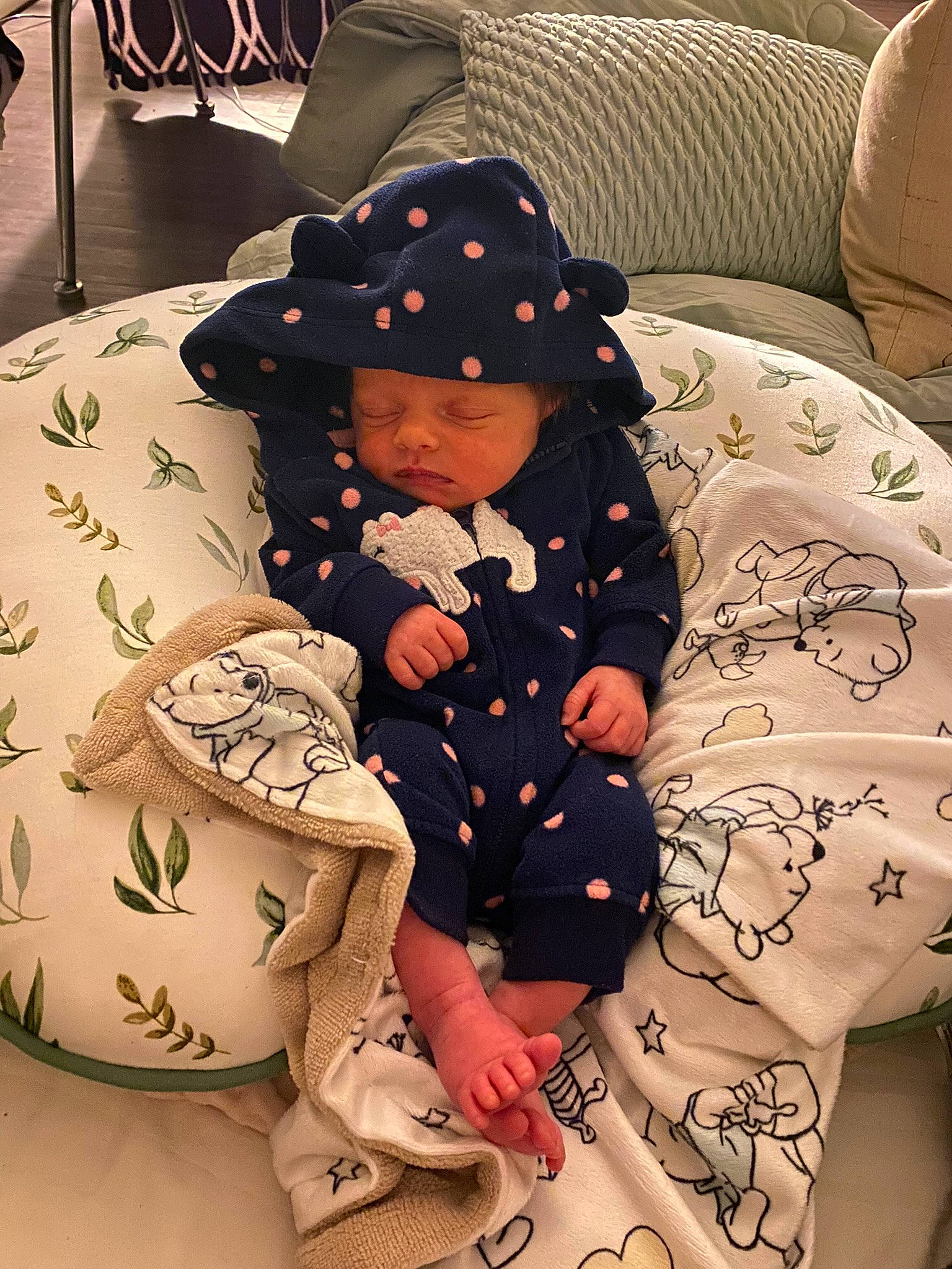 Isla is registered to the contest to win money with this photo: baby, baby_products, baby_toddler_clothing, bedding, cap, child, comfort, fedora, hat, headwear, human_leg, linens, pattern, person, room, sitting, sleeve, sun_hat, textile, thigh